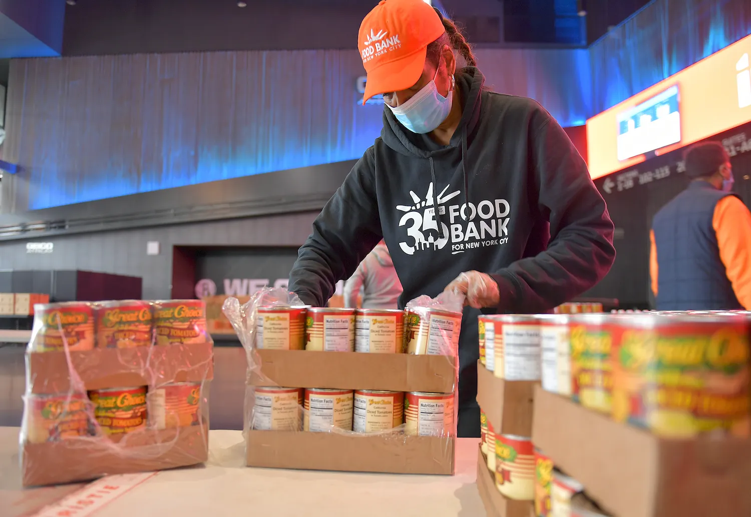 A woman unpacks canned food at a food bank in New York City.