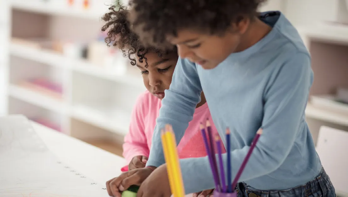 Two young children drawing and coloring