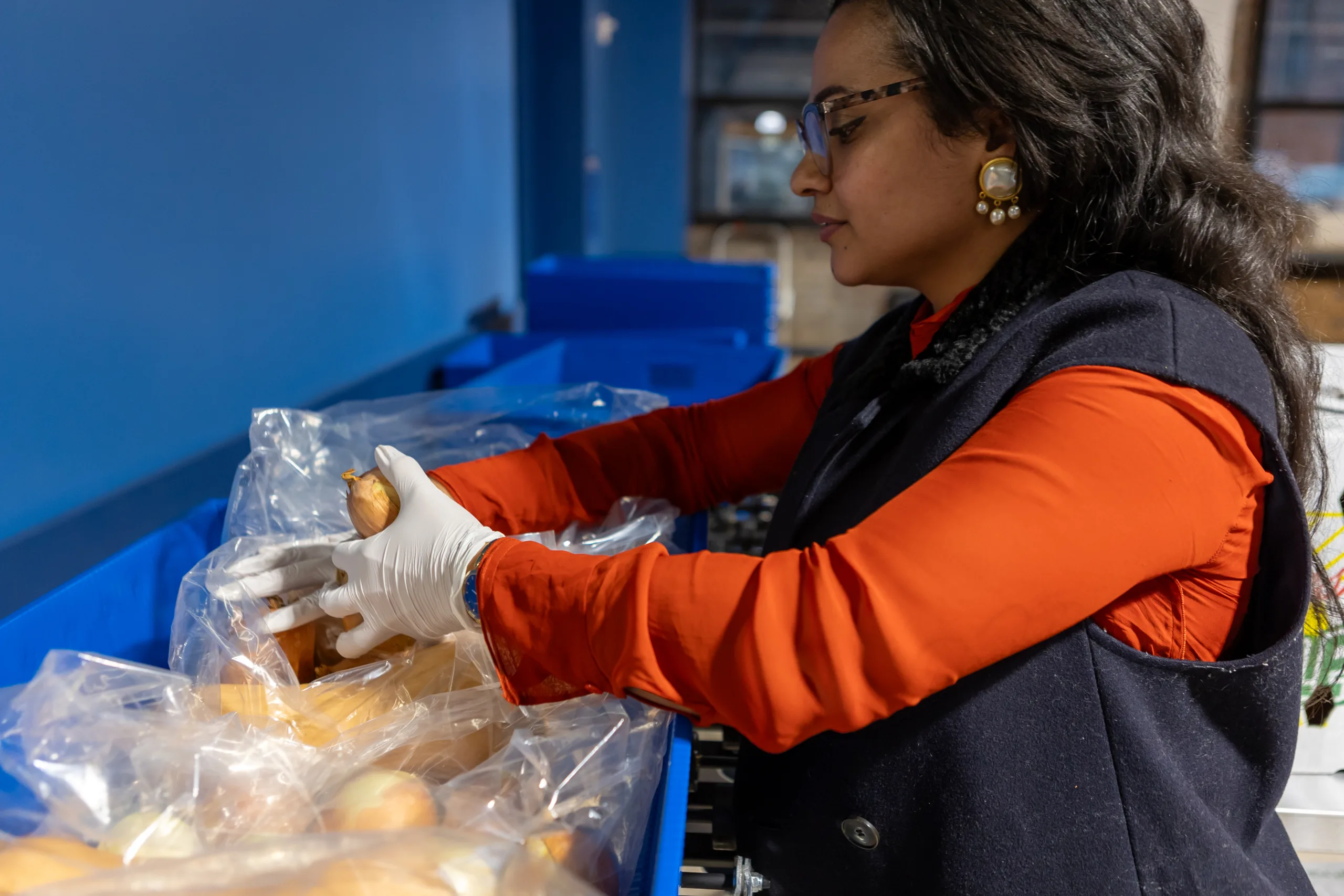 A woman packing grocery bags at a food distribution factory