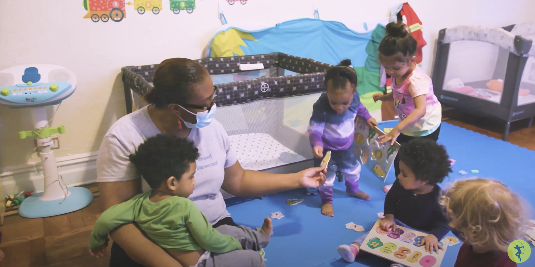 A group of toddlers with a caregiver in a home-based child care setting.