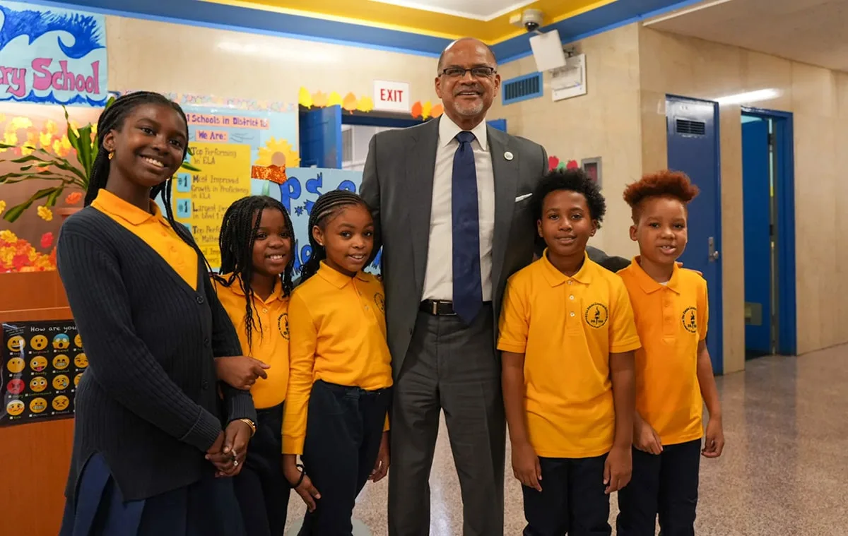 NYC Schools Chancellor Banks posing with a teacher and four elementary school students.