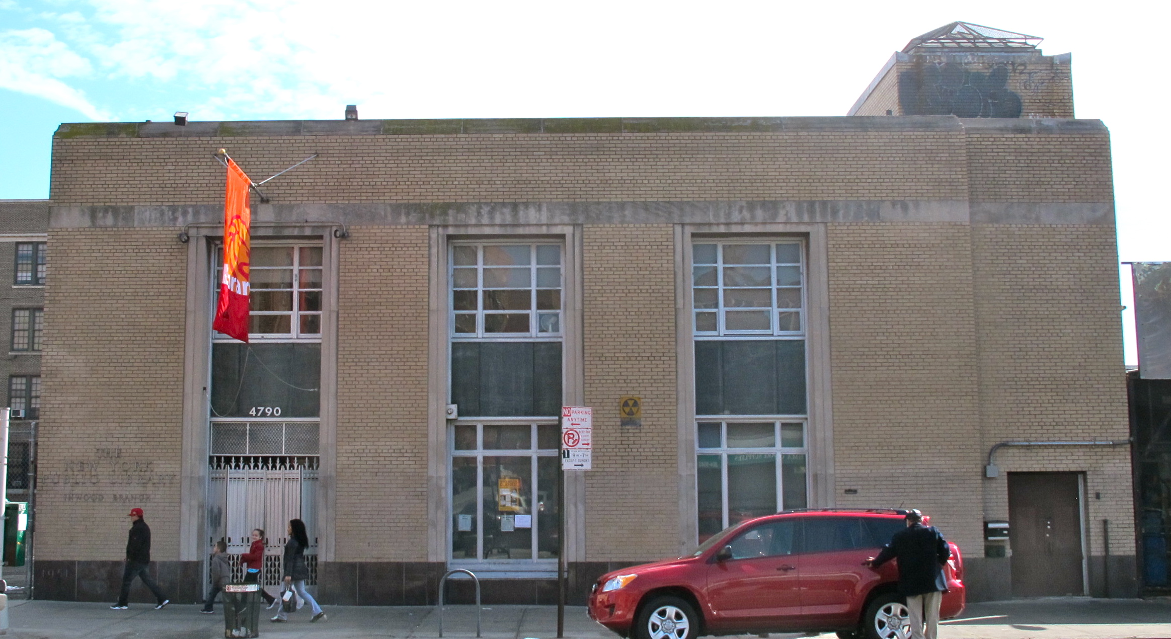 A shot of the exterior facade of a public library building in Inwood.